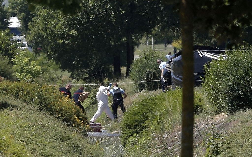 Investigating police officers work outside the plant where a terrorist attack took place, Friday, June 26, 2015 in Saint-Quentin-Fallavier, southeast of Lyon, France. (AP Photo/Laurent Cipriani)