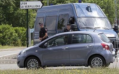 Police officers guard the road leading to a plant in Saint-Quentin-Fallavier, southeast of Lyon, France, Saturday, June 27, 2015, where an attack took place yesterday June 26. (AP/Michel Euler)