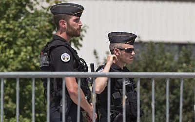 Police officers guard a road leading to a plant which was attacked on Friday in Saint-Quentin-Fallavier, southeast of Lyon, France, Saturday, June 27, 2015. (AP/Michel Euler)