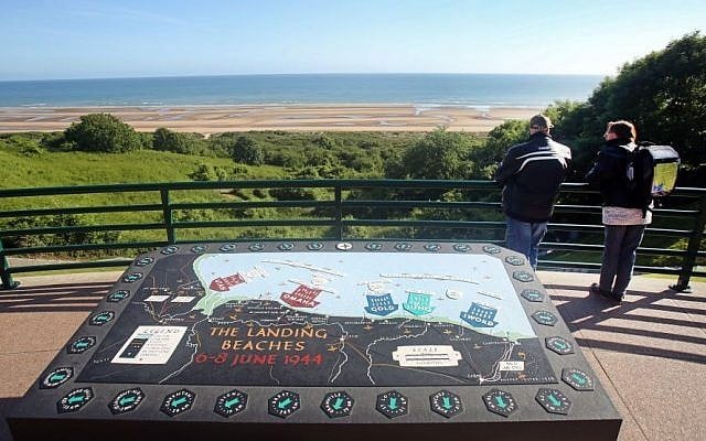 Two visitors look out over Omaha Beach from the Colleville American military cemetery, in Colleville sur Mer, western France, Saturday June 6, 2015, on the 71st anniversary of the D-Day landing. (AP/Remy de la Mauviniere)
