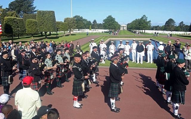 Visitors and cadets from Annapolis U.S. navy academy, Maryland, background, watch a bagpipe band parading at the Colleville American military cemetery, in Colleville sur Mer, western France, Saturday June 6, 2015, as part of the commemoration of the 71st anniversary of the D-Day landing. (AP/Remy de la Mauviniere)