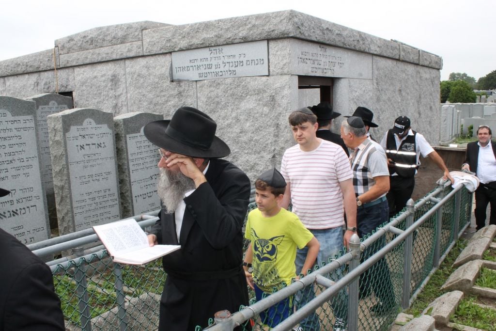 Male visitors wait on line on June 21, 2015 before entering the 'Ohel,' the grave of the Lubavitcher Rebbe Menachem Mendel Schneerson, on the 21st anniversary of his death. (Hannah Dreyfus/The Times of Israel) Male visitors on June 21, 2015 exit the 'Ohel,' the grave of the Lubavitcher Rebbe Menachem Mendel Schneerson, on the 21st anniversary of his death. (Hannah Dreyfus/The Times of Israel)