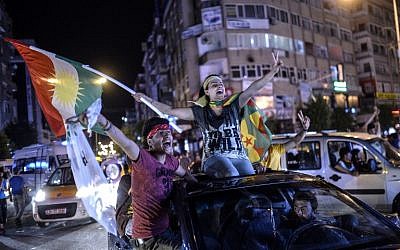 TOPSHOTS Young supporters of pro-Kurdish Peoples' Democratic Party (HDP) hold Kurdish flags as they celebrate the results of the legislative election, in Diyarbakir on June 7, 2015. The HDP easily surpassed the 10 percent barrier needed to send MPs to parliament. Under Turkey's proportional representation system, this means the Turkey's Islamic-rooted Justice and Development Party (AKP) will need to form a coalition for the first time since it first came to power in 2002. AFP PHOTO / BULENT KILIC