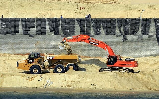 Bulldozers and trucks work on a new section of the Suez canal during a media tour in Ismailia, Egypt, Saturday, June 13, 2015.(AP Photo/Hassan Ammar)