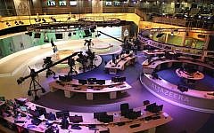 In this Jan. 1, 2015, file photo, staff members of Al-Jazeera International work at the news studio in Doha, Qatar. Ahmed Mansour, a prominent Al-Jazeera Arabic journalist, was detained Saturday, June 20, in Germany over an Egyptian arrest warrant, the Qatar-based broadcaster reported. (AP/Osama Faisal)