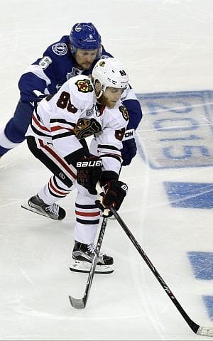 Tampa Bay Lightning defenseman Anton Stralman, back, battles Chicago Blackhawks right wing Patrick Kane for the puck with during the first period in Game 2 of the NHL hockey Stanley Cup Final on Saturday, June 6, 2015, in Tampa Fla. (AP Photo/John Raoux)