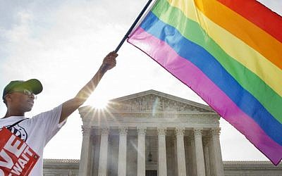 Carlos McKnight of Washington, waves a flag in support of gay marriage outside of the Supreme Court in Washington, Friday June 26, 2015. (AP/Jacquelyn Martin)