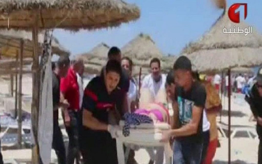 In this screen grab taken from video provided by Tunisia TV1, injured people are treated on a Tunisian beach Friday June 26, 2015. Two gunmen rushed from the beach into a hotel in the Tunisian resort town of Sousse Friday, killing at least 37 people and wounding six others in the latest attack on the North African country's key tourism industry, the Interior Ministry said. (Tunisia TV1 via AP)