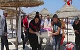 Injured people are treated on a Tunisian beach Friday, June 26, 2015 after a terror attack in which more than 30 people were killed. (Tunisia TV1 via AP)