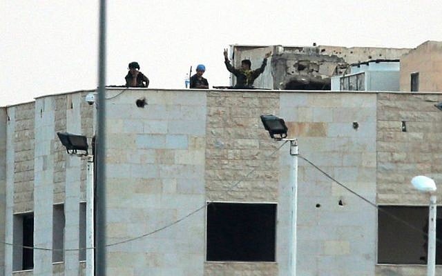 In this photo taken from the Turkish side of the border between Turkey and Syria, in Akcakale, southeastern Turkey, Kurdish fighters wave and flash the V-sign as the hold their positions atop pf a building in the outskirts of Tal Abyad, Syria, Monday, June 15, 2015 (AP Photo/Lefteris Pitarakis) In this photo taken from the Turkish side of the border between Turkey and Syria, in Akcakale, southeastern Turkey, Kurdish fighters wave and flash the V-sign as the hold their positions atop pf a building in the outskirts of Tal Abyad, Syria, Monday, June 15, 2015 (AP Photo/Lefteris Pitarakis)