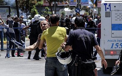 Turkish riot policemen grab a man during clashes  in Erzurum between Turkish nationalists and supporters of pro-Kurdish People's Democratic Party (HDP) on June 4, 2015. (AFP/Ihlas News Agency)