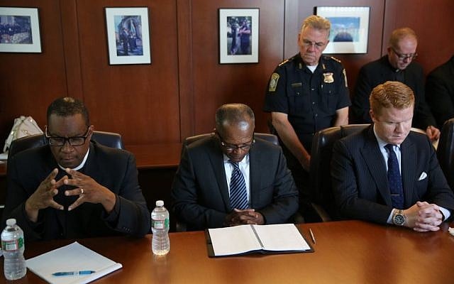 Community members and police officials pray at the Boston Police Department headquarters before seeing a video, Wednesday, June 3, 2015, in Boston, of a fatal police shooting on Tuesday, in the city's Roslindale neighborhood. (David Ryan/The Boston Globe via AP, Pool) Community members and police officials pray at the Boston Police Department headquarters before seeing a video, Wednesday, June 3, 2015, in Boston, of a fatal police shooting on Tuesday, in the city's Roslindale neighborhood. (David Ryan/The Boston Globe via AP, Pool)