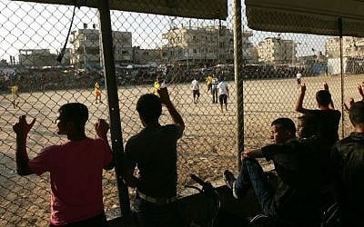 Palestinian youths watch a local soccer match at a refugee camp in Rafah, in the southern Gaza Strip, July 14, 2013. (Abed Rahim Khatib/Flash90)