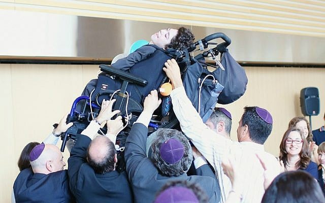 Friends and family lift Jacob Trossman as they dance at his bar mitzvah celebration in Toronto on May 18, 2015. (Nechama Laitman Photography)