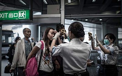 Passengers get their temperature checked as part of preventive measures against the spread of Middle East Respiratory Syndrome (MERS) at the Hong Kong international airport on June 5, 2015. (AFP/Philippe Lopez)