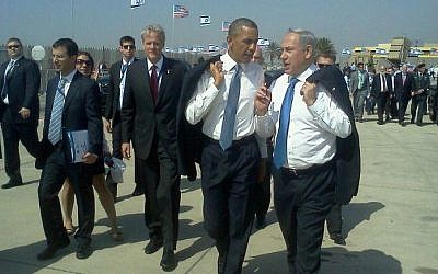 Prime Minister Benjamin Netanyahu and President Barack Obama talk at Ben Gurion Airport after Obama's arrival in Israel in March 2013. Michael Oren walks behind Obama (Via Facebook)