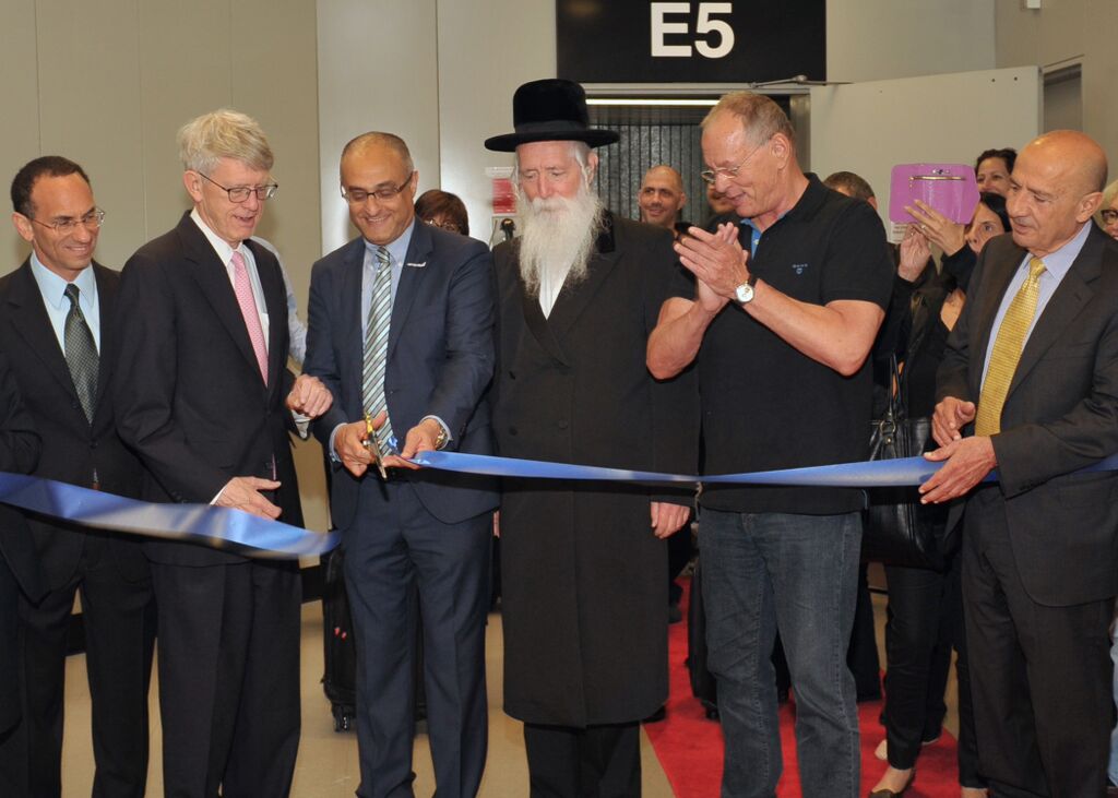 During a ceremony conducted at Boston’s Logan International Airport on June 28, 2015, officials cut a ribbon outside the new Boston-TLV nonstop flight’s boarding gate. Pictured (from left) are Israel’s Consul-General to New England, Yehuda Yaakov; Chief Executive Officer of the Massachusetts Port Authority, Thomas Glynn; El Al CEO, David Maimon; Rabbi Yitvhal Dovid Grossman; El Al Chairman Amikam Cohen, and El Al Vice President and Project Manager, Boston route, Danny Saadon. (photo credit: Allan Dines/Massport) During a ceremony conducted at Boston’s Logan International Airport on June 28, 2015, officials cut a ribbon outside the new Boston-TLV nonstop flight’s boarding gate. Pictured (from left) are Israel’s Consul-General to New England, Yehuda Yaakov; Chief Executive Officer of the Massachusetts Port Authority, Thomas Glynn; El Al CEO, David Maimon; Rabbi Yitvhal Dovid Grossman; El Al Chairman Amikam Cohen, and El Al Vice President and Project Manager, Boston route, Danny Saadon. (photo credit: Allan Dines/Massport)
