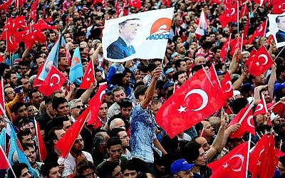 People wave Turkish flags, including one bearing the image of President Recep Tayyip Erdogan, on May 30, 2015, during a campaign rally. (AFP/Ozan Kose)