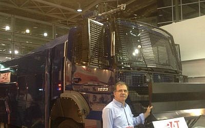 Meir Yakter, alongside Beit Alfa Technologies' riot-control vehicle on June 2, 2015 (Mitch Ginsburg/ Times of Israel)