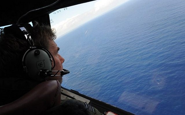 This file photo taken from a Royal New Zealand Air Force (RNZAF) P-3K2-Orion aircraft on April 13, 2014 shows co-pilot and squadron leader Brett McKenzie helping to look for objects during the search for missing Malaysia Airlines flight MH370, off Perth in Western Australia. (AFP/Pool/Greg Wood) This file photo taken from a Royal New Zealand Air Force (RNZAF) P-3K2-Orion aircraft on April 13, 2014 shows co-pilot and squadron leader Brett McKenzie helping to look for objects during the search for missing Malaysia Airlines flight MH370, off Perth in Western Australia. (AFP/Pool/Greg Wood)
