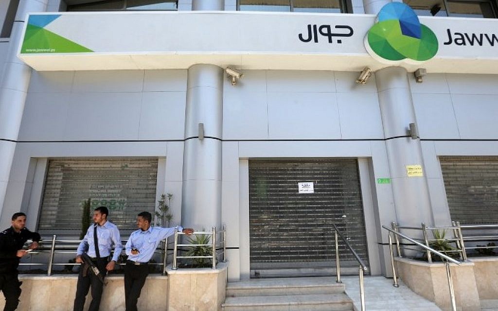 Hamas police stand guard in front of the Jawwal company's headquarters in Gaza City on June 30, 2015. (AFP/Mahmud Hams)