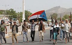 Yemeni fighters loyal to exiled President Abd Rabbo Mansour Hadi hold the movement's flag and brandish their weapons in Aden's Khormaksar district, on July 15, 2015. (AFP/Saleh al-Obeidi)