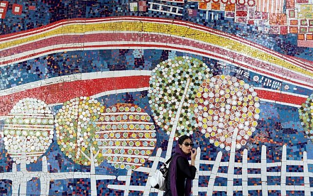 An Iranian woman walks past graffiti on a street northwest of the capital Tehran, on July 16, 2015. (AFP/ATTA KENARE) An Iranian woman walks past graffiti on a street northwest of the capital Tehran, on July 16, 2015. (AFP/ATTA KENARE)