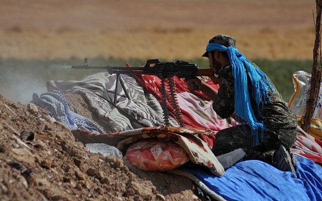 A member of the Kurdish People's Protection Units (YPG) fires towards Islamic State (IS) group jihadists on the southern outskirts of the northeastern Syrian city of Hasakeh on July 20, 2015.(AFP PHOTO / DELIL SOULEIMAN)