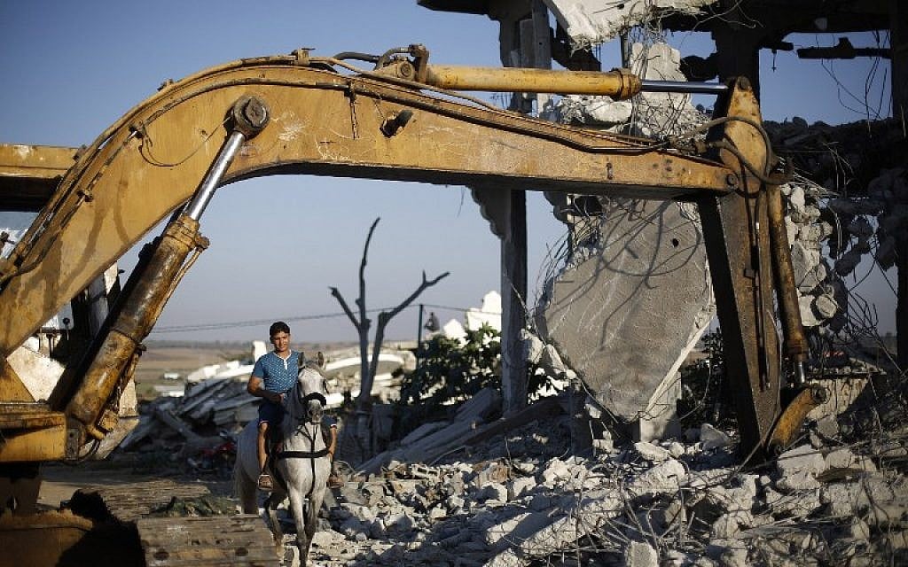 A Palestinian man rides his horse through the rubble of buildings, reportedly destroyed during the 50-day war between Israel and Hamas in the summer of 2014, in Gaza City on July 21, 2015 (AFP PHOTO / MOHAMMED ABED)