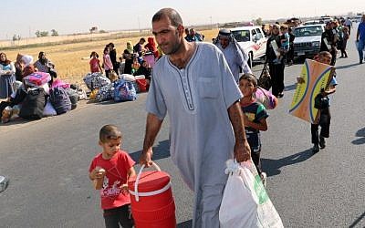 Displaced Iraqis carry their belongings on July 22, 2015 at a gathering point in the northern city of Kirkuk. (AFP / MARWAN IBRAHIM)
