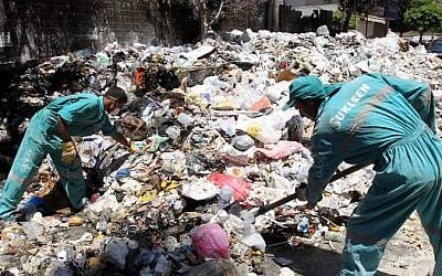 Lebanese street cleaners start to collect rubbish from the streets of Beirut on July 26, 2015 (Anwar Amro/AFP)