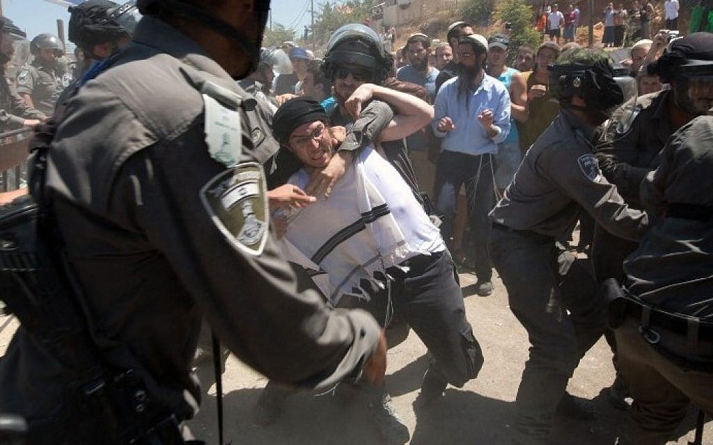 Israeli settlers scuffle with Israeli security forces as the demolition started of the so-called Dreinoff buildings under an Israeli High Court ruling in the settlement of Beit El, north of Ramallah, 29 July, (AFP/MENAHEM KAHANA)