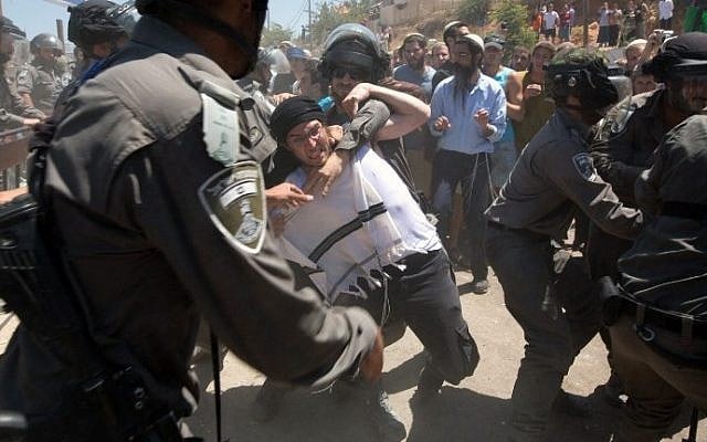 Israeli settlers scuffle with Israeli security forces as the demolition started of the so-called Dreinoff buildings under an Israeli High Court ruling in the settlement of Beit El, north of Ramallah, 29 July, (AFP/MENAHEM KAHANA)