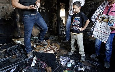 Palestinians inspect the damage as they stand in a house in the West Bank village of Duma set on fire in an apparent attack by Jewish terrorists, which killed 18-month-old Palestinian toddler Ali Saad Dawabsha on July 31, 2015. (AFP PHOTO/THOMAS COEX)
