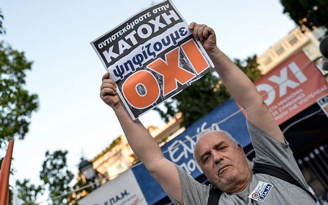 A man holds a board that reads 'No' for the vote in the Greek referendum, as he celebrates at Syntagma Square in Athens after the first exit polls of a referendum on austerity measures, July 5, 2015. (AFP/Andreas Solaro)