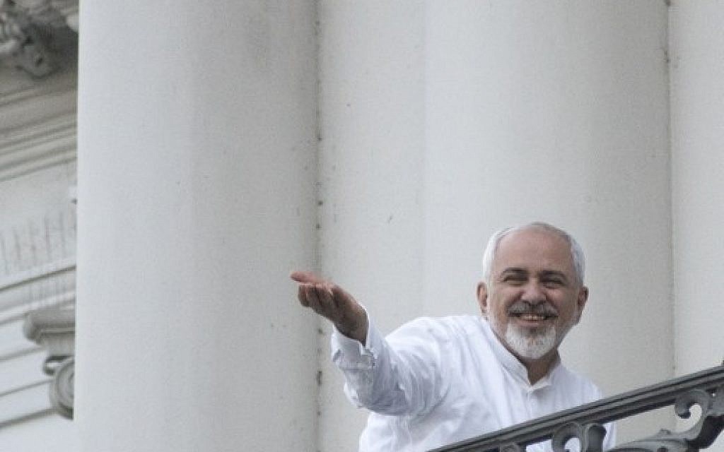 Iranian Foreign Minister Mohammad Javad Zarif gestures toward reporters as he talks with Iranian Deputy Foreign Minister, Iranian deputy foreign minister for European and American Affairs, and the brother of the Iranian president (not pictured) onto a balcony of the Palais Coburg Hotel, where the Iran nuclear talks meetings are being held in Vienna on July 11, 2015 (AFP PHOTO / JOE KLAMAR)