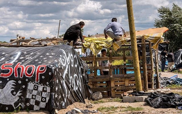 Migrants build a makeshift shelter at a site dubbed the "new jungle", where migrants trying to cross the Channel to reach Britain have camped out around the northern French port of Calais, on July 29, 2015. (AFP PHOTO / PHILIPPE HUGUEN)