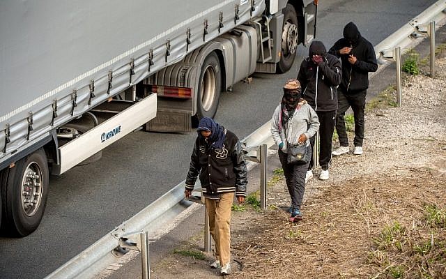 Migrants walk alongside vehicles on the route leading to the Eurotunnel in Coquelles on July 29, 2015.  (AFP PHOTO / PHILIPPE HUGUEN)
