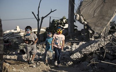 Palestinian children play in the rubble of buildings, reportedly destroyed during the 50-day war between Israel and Hamas militants in the summer of 2014, in Gaza City on July 21, 2015. (AFP / MOHAMMED ABED)