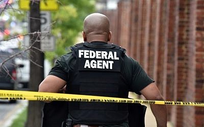 A federal agent patrols near the scene of an unconfirmed shooting at the Navy Yard in Washington, DC on July 2, 2015. (AFP PHOTO/ MLADEN ANTONOV)