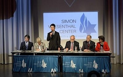 Hikaru Kimura, third from left, a Mitsubishi Materials Corp. senior executive, stands as he apologizes to James Murphy, second right, a US World War II prisoner of war who was used for slave labor during WWII, at the Simon Wiesenthal Center's Museum of Tolerance, Los Angeles, July 19, 2015. (AFP/ROBYN BECK)