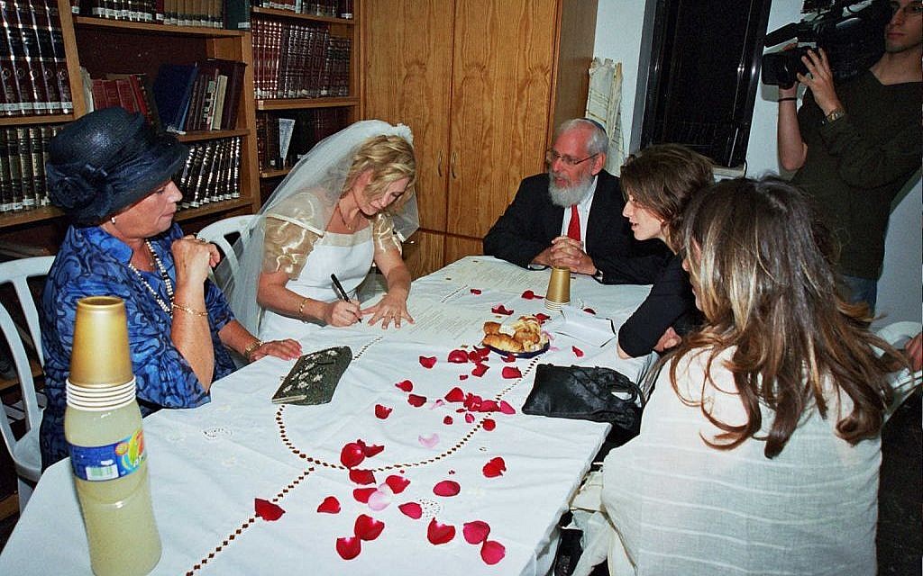 Nathalie Lastreger signing her ketubba (marriage contract) ahead of her 2004 Conservative unreported private wedding ceremony. (courtesy) Nathalie Lastreger signing her ketubba (marriage contract) ahead of her 2004 Conservative unreported private wedding ceremony. (courtesy)