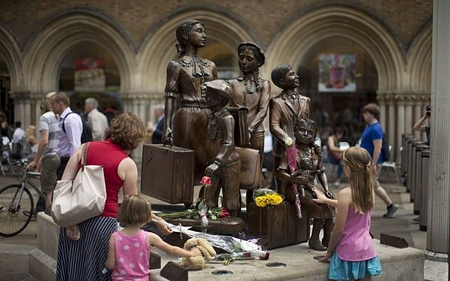 People look at flowers laid in memory of Britain's Sir Nicholas Winton on German-born Jewish sculptor Frank Meisler's 'Kindertransport' (German for children transport) memorial statue outside Liverpool Street Station in London, Thursday, July 2, 2015. (AP Photo/Matt Dunham)