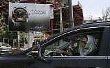 A woman drives in front of an advertising billboard for Bulgari watches in northern Tehran, Iran, Saturday, July 18, 2015. (AP/Vahid Salemi)