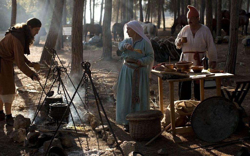 Israeli and Russian members of knight clubs cook their breakfast before the reenactment of the Battle of Hattin in Lavi Forest, northern Israel, July 4, 2015. (AP/Oded Balilty)