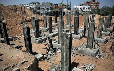 Palestinian workers rebuilding a house as reconstruction begins in the Shejaiya neighborhood of Gaza City, July 23, 2015. (AP/Khalil Hamra) Palestinian workers rebuilding a house as reconstruction begins in the Shejaiya neighborhood of Gaza City, July 23, 2015. (AP/Khalil Hamra)