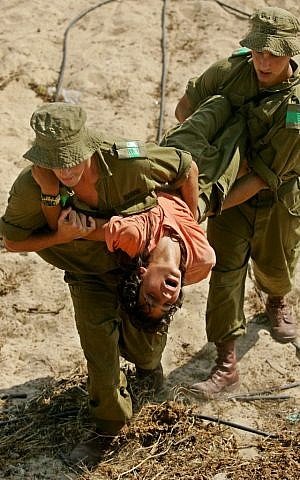 sraeli soldiers carry a teenager at the Jewish settlement of Shirat Hayam in Gush Katif bloc of settlements in the Gaza Strip Wednesday Aug. 17, 2005. (AP Photo/Ariel Schalit)