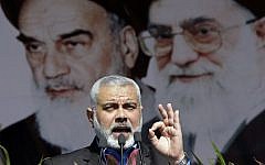 Hamas political leader Ismail Haniyeh delivers a speech in front of portraits of late Iranian revolutionary founder Ayatollah Khomeini (left), and supreme leader Ayatollah Ali Khamenei (right), at a rally in Tehran, February 11, 2012. (AP/Vahid Salemi)