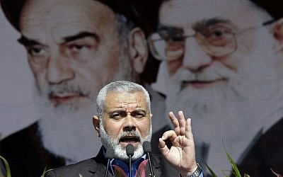 Hamas political leader Ismail Haniyeh delivers a speech in front of portraits of late Iranian revolutionary founder Ayatollah Khomeini (left), and supreme leader Ayatollah Ali Khamenei (right), at a rally in Tehran, February 11, 2012. (AP/Vahid Salemi)