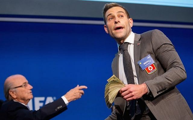 Comedian Simon Brodkin prepares to attack FIFA President Joseph S. Blatter (R) with money during a press conference at the Extraordinary FIFA Executive Committee Meeting at the FIFA headquarters on July 20, 2015 in Zurich, Switzerland. (JTA/Philipp Schmidli/Getty Images) Comedian Simon Brodkin prepares to attack FIFA President Joseph S. Blatter (R) with money during a press conference at the Extraordinary FIFA Executive Committee Meeting at the FIFA headquarters on July 20, 2015 in Zurich, Switzerland. (JTA/Philipp Schmidli/Getty Images)